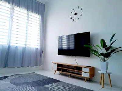 a living room with a tv and a potted plant at Zayyan Homestay Parit Buntar in Parit Buntar