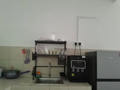 a kitchen with a sink and a refrigerator at Zayyan Homestay Parit Buntar in Parit Buntar