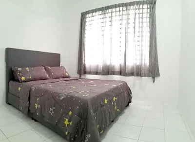a bed in a room with a window and a bedspread at Zayyan Homestay Parit Buntar in Parit Buntar