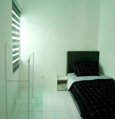 a white room with a bed and a window at Zayyan Homestay Parit Buntar in Parit Buntar
