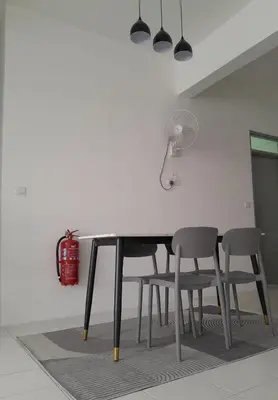 a dining room table with two chairs and a lamp at Zayyan Homestay Parit Buntar in Parit Buntar