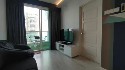 a living room with a television and a door with a balcony at Mansion One 279 in George Town