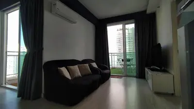 a black couch in a living room with windows at Mansion One 279 in George Town