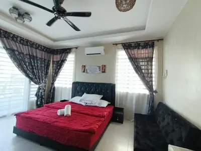 a bedroom with a red bed with two white towels on it at Inap Kluster Height , Kuala Kangsar in Kuala Kangsar