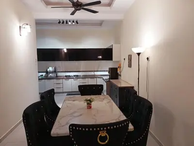 a dining room table with black chairs and a ceiling fan at Inap Kluster Height , Kuala Kangsar in Kuala Kangsar
