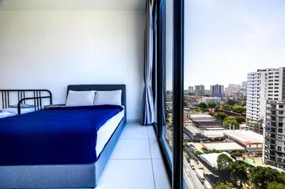 a bedroom with a bed and a view of a city at Beacon Suites #Georgetown #FamilyStay #13A #Cozy in George Town