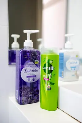 a couple of bottles of toothpaste and tooth paste on a bathroom counter at Beacon Suites #Georgetown #FamilyStay #13A #Cozy in George Town