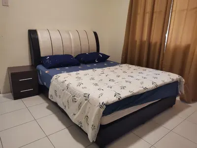 a bedroom with a bed with blue and white sheets at Ummus Homestay in Tanah Rata