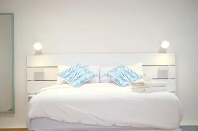 a white bed with blue and white pillows on it at Tung Kidcove Centrum Cameron in Brinchang
