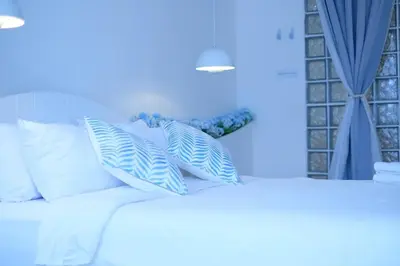 a white bed with white pillows and a blue wall at Tung Kidcove Centrum Cameron in Brinchang