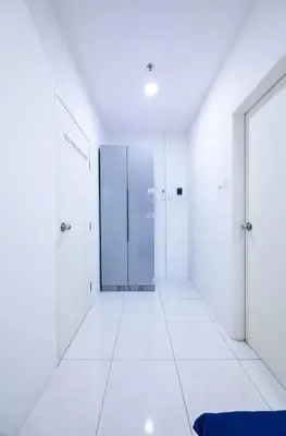 a hallway with white walls and doors and a blue bench at The Sun #3BR #11 FamilyStay #BayanLepas in Bayan Lepas