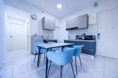 a kitchen with a table and some blue chairs at The Sun #3BR #11 FamilyStay #BayanLepas in Bayan Lepas