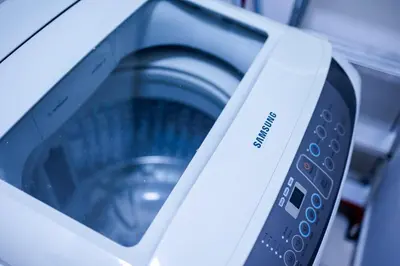 a close up of a washing machine with a remote control at The Sun #3BR #11 FamilyStay #BayanLepas in Bayan Lepas
