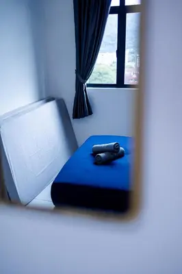 a remote control sitting on a blue cushion in front of a window at The Sun #3BR #11 FamilyStay #BayanLepas in Bayan Lepas