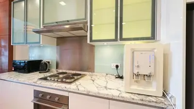 a kitchen with a stove and a counter top at Straits Quay Highest & Spacious Seaview Suite - 3 in Bagan Jermal