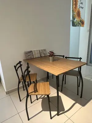 a wooden table with two chairs and a table with a plant on it at horizon ipoh in Ipoh