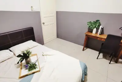 a bedroom with a bed with a table and a desk at Ipoh Kinta Riverfront Air-Con Cozy Home in Ipoh