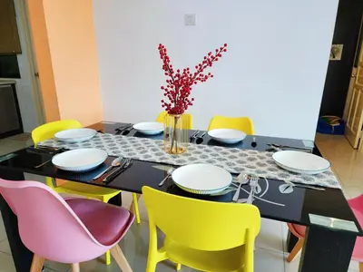 a dining room with a table with yellow chairs at Ipoh Kinta Riverfront Air-Con Cozy Home in Ipoh