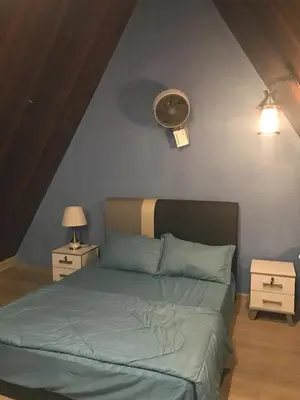 a bedroom with a bed and a clock on the wall at KK Farm Stay in Ringlet