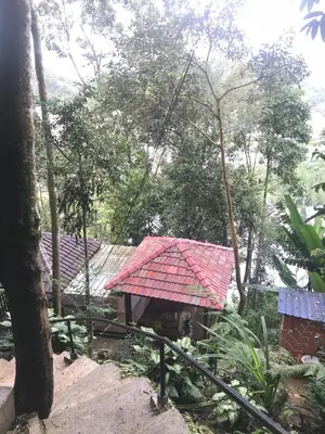 a group of houses with a red roof at KK Farm Stay in Ringlet