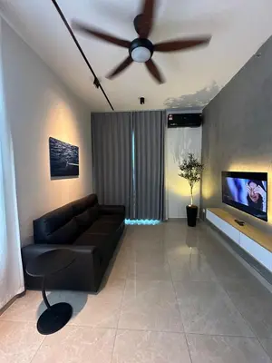 a living room with a black couch and a ceiling fan at ICC Premier Suites Ipoh City Centre by Landmark in Ipoh