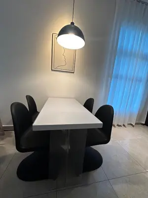 a white table with black chairs and a light at ICC Premier Suites Ipoh City Centre by Landmark in Ipoh