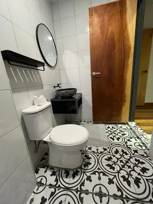 a bathroom with a toilet and a wooden door at Villa Aman in Georgetown in George Town
