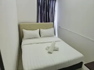 a white bed with a towel on top of it at Cool memories smart stay in Tanah Rata