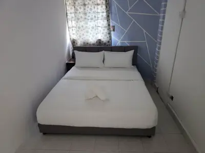 a bedroom with a bed with white sheets and a window at Cool memories smart stay in Tanah Rata