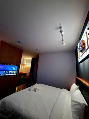 a bedroom with a white bed and a flat screen tv at Eng Wan Hotel in Kamunting
