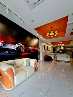 a living room with a white couch and a car mural at Eng Wan Hotel in Kamunting