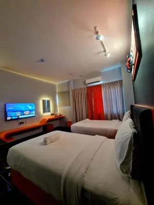 a hotel room with two beds and a flat screen tv at Eng Wan Hotel in Kamunting