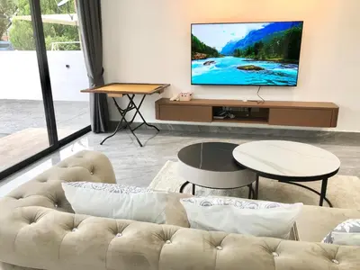a living room with a couch and a tv on a wall at BigLanded House NR Penang Hill & Kek Lok Si Temple in Ayer Itam