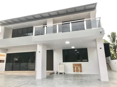 a white house with black windows and a balcony at BigLanded House NR Penang Hill & Kek Lok Si Temple in Ayer Itam