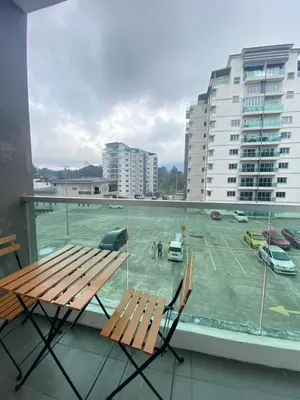 a balcony with a bench and a parking lot at Qaseh Homestay Cameron Highlands The Quintet Apartment Tanah Rata in Tanah Rata