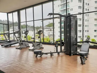 a gym with a bunch of treadmills and ellipticals at Qaseh Homestay Cameron Highlands The Quintet Apartment Tanah Rata in Tanah Rata