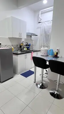 a kitchen with white cabinets and a table and chairs at ANAS Homestay in Ipoh