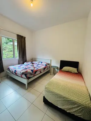 a bedroom with two beds and a window at AYAAN QUINTET FAMILY HoMESTAY Free Parking in Tanah Rata