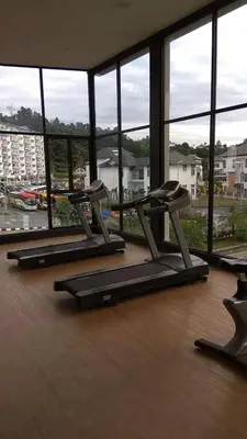 a group of treadmills in a room with a large window at AYAAN QUINTET FAMILY HoMESTAY Free Parking in Tanah Rata