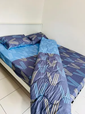 a bed with a blue comforter and pillows on it at AYAAN QUINTET FAMILY HoMESTAY Free Parking in Tanah Rata