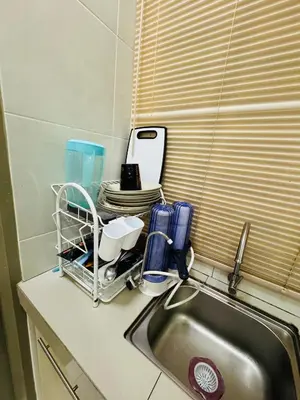 a kitchen counter with a sink and a drying rack at AYAAN QUINTET FAMILY HoMESTAY Free Parking in Tanah Rata