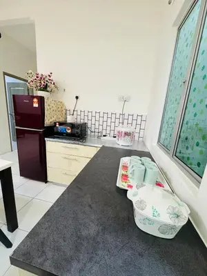 a kitchen with a counter with a sink and a refrigerator at AYAAN QUINTET FAMILY HoMESTAY Free Parking in Tanah Rata
