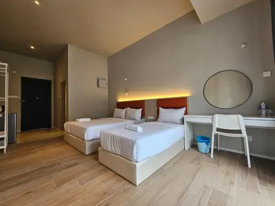a hotel room with two beds and a mirror at Swettenham Room at Weld Quay Georgetown in George Town