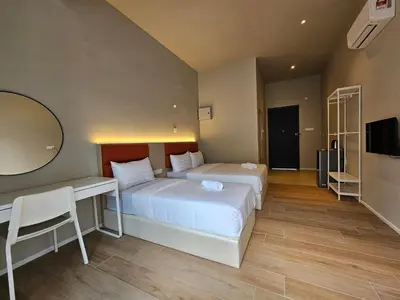 a bedroom with two beds and a desk and a television at Swettenham Room at Weld Quay Georgetown in George Town