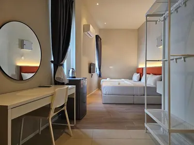 a hotel room with a bed and a mirror at Swettenham Room at Weld Quay Georgetown in George Town