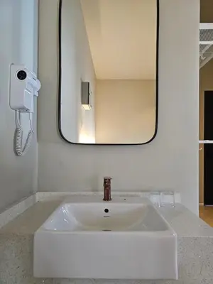 a white sink in a bathroom with a mirror at Swettenham Room at Weld Quay Georgetown in George Town