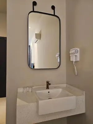a bathroom sink with a mirror and a phone at Swettenham Room at Weld Quay Georgetown in George Town