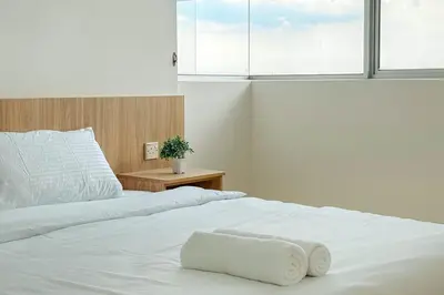 a white bed with a white towel on it at Taiping Peaceful Retreat near Lake Garden with WiFi in Taiping