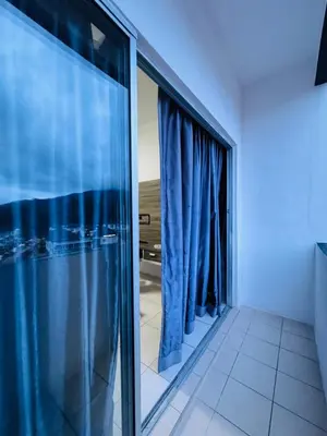 a room with blue curtains and a large window at AYAAN HOMESTAY HILL VIEW INN 2 FREE Wifi and Netflix in Cameron Highlands
