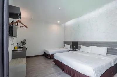 a hotel room with two beds and a tv at Indra Hotel Ipoh in Ipoh